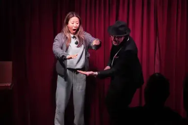 Audience volunteer amazed during magic performance on stage