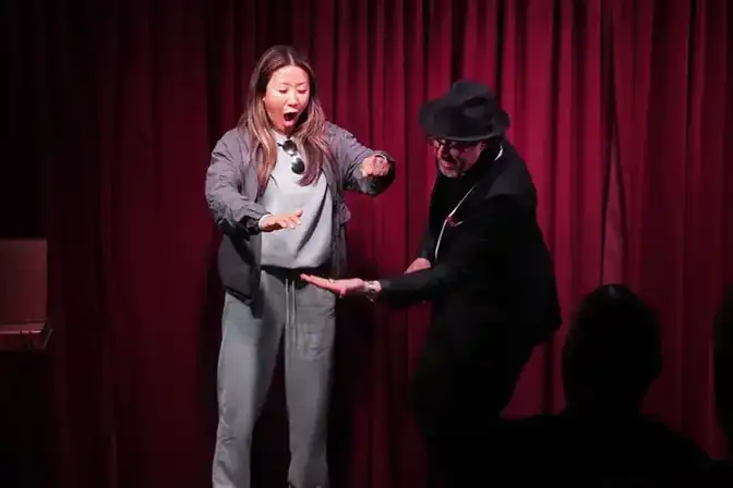 Audience volunteer amazed during magic performance on stage