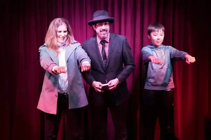 Jay Alexander on stage with two audience volunteers