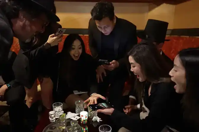 Amazed guests reacting to close-up magic in the lounge