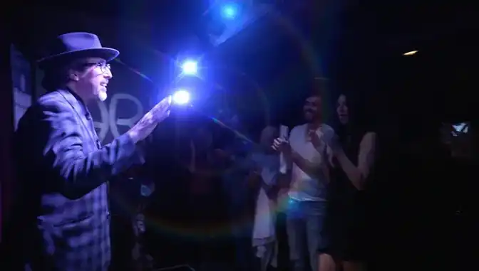 Jay Alexander receiving standing ovation with blue stage lights